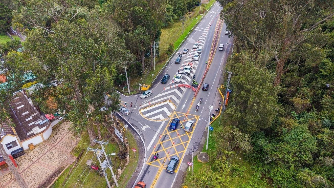 Vista aérea de una intersección vial con vehículos circulando y señalización en la carrera Séptima en Bogotá